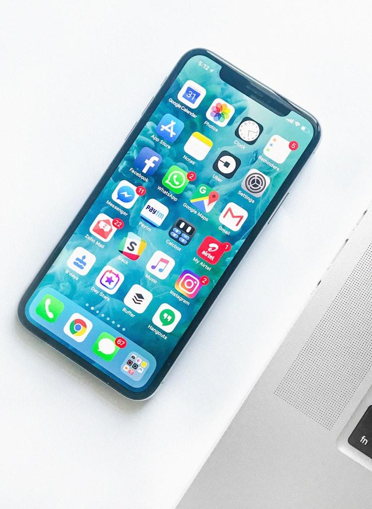 Teléfono con WhatsApp listo para atender clientes junto a la laptop